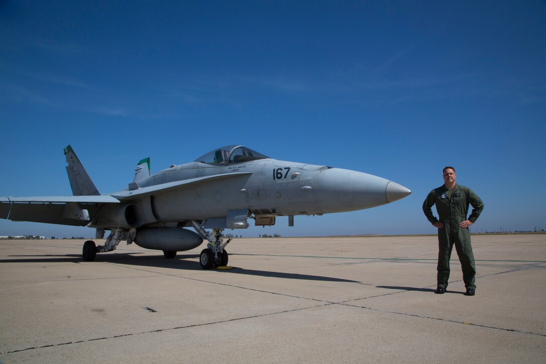 U.S. Marine Corps Lt. Col. Jarrod DeVore, an F/A-18C Hornet pilot with Marine Fighter Attack Training Squadron (VMFAT) 101, Marine Aircraft Group 11, 3rd Marine Aircraft Wing, poses in front of a Hornet at the San Diego Jet Center, San Diego, Calif., July 27, 2019. VMFAT-101 is the largest F/A-18 squadron in the Marine Corps and has over 60 fighter jets attached to the squadron. (U.S. Marine Corps photo by Sgt. Victoria Decker)