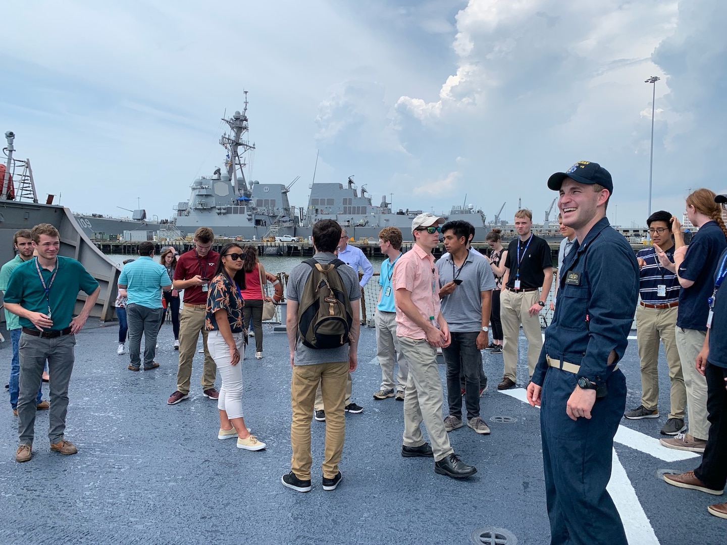 Lt. j.g. Sebastian Welch (right) gives Naval Surface Warfare Center, Carderock Division employees and interns an overview of USS Mahan’s (DDG 72) helo deck before embarking on a tour of the Arleigh Burke-class destroyer during Carderock’s “Meet-the-Fleet” trip to Naval Station Norfolk on July 16, 2019. (U.S. Navy photo by Lydia Weyrich/Released)