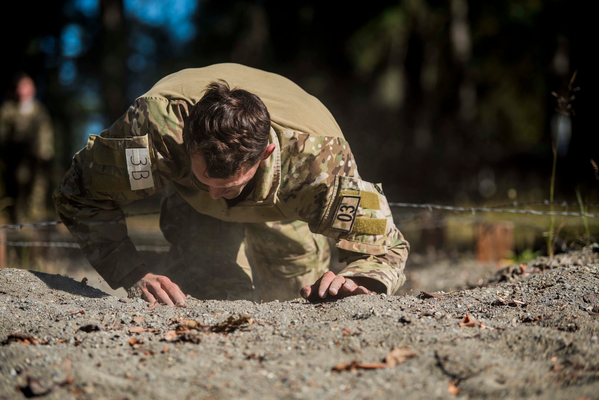 A U.S. Air Force Tactical Air Control Party (TACP) Airman assigned to the 5th Air Support Operations Squadron, Joint Base Lewis-McChord (JBLM), Wash., low crawls through sand during the 2019 Lightning Challenge at JBLM, Wash., July 29, 2019.