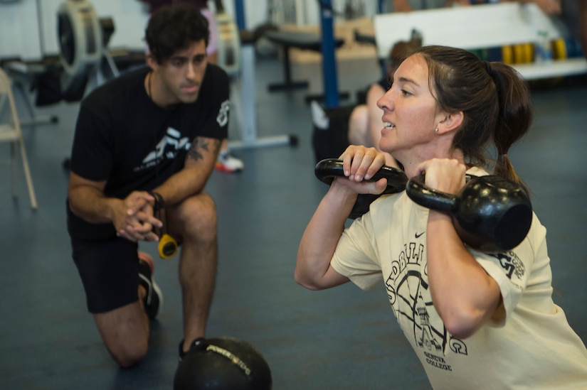 U.S. Air Force Senior Airman Karissa Lee, right, a reservist with the 911th Security Forces Squadron command support staff, Pittsburgh Air Reserve Station, Pa., raises kettle bells while performing squat exercises as Jonathan Zananiri, Alpha Warrior fitness program manager, observes her exercise form, during the Alpha Warrior Super Regional event July 27, 2019, at Joint Base Charleston, S.C. Twelve Airmen competed, tackling a variety of functional fitness obstacles, while utilizing the Joint Base Charleston Fitness Center’s Alpha Warrior battle rig. The competition focuses on a competitor’s overall readiness and is designed to promote more fit and resilient service members.