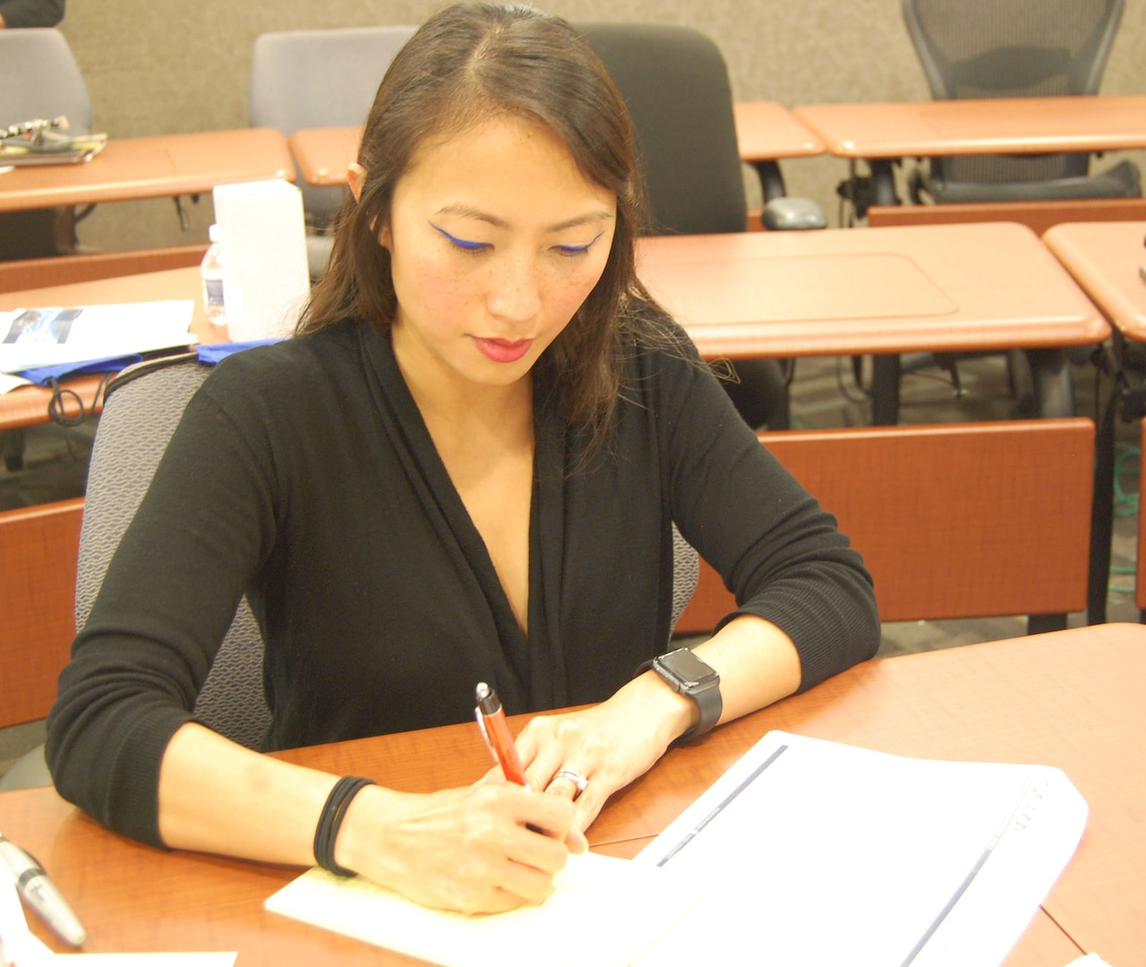 Female employee reading a briefing and taking notes