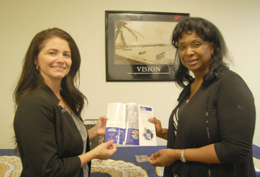 Photo of two female employees reviewing a DCMA brochure