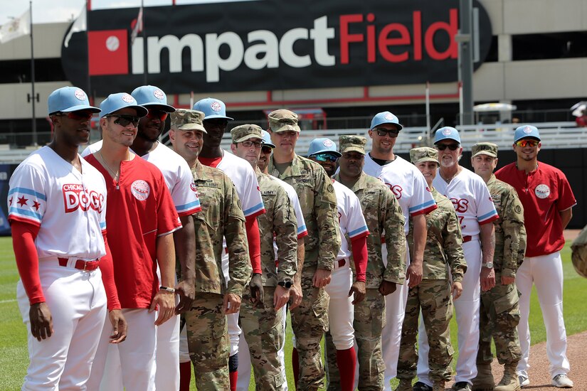 Army Reserve Soldiers assigned to the 85th U.S. Army Reserve Support Command headquarters pause for a photo with players from the American Association of Independent Professional Baseball’s Chicago Dogs baseball team, July 28, 2019, at Impact Field in Rosemont, Illinois during a home game there against the Cleburne Railroaders.