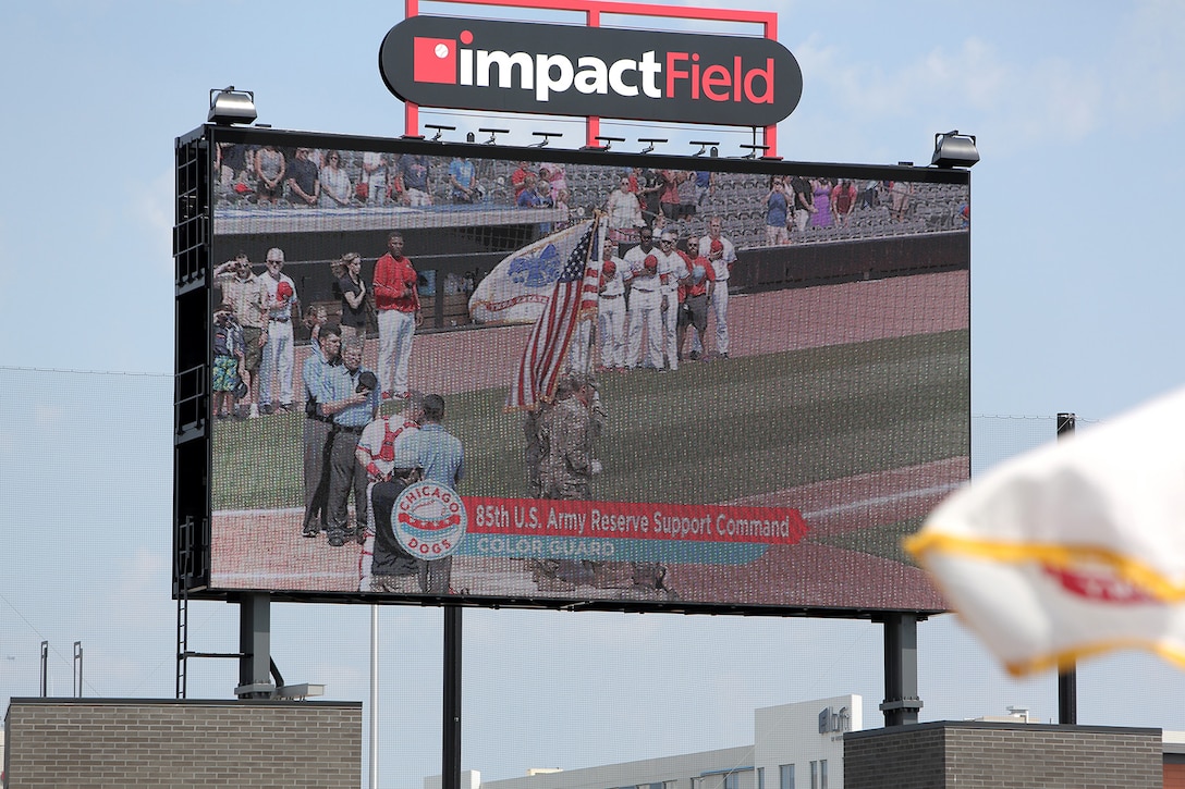 An Army Reserve color guard team, assigned to the 85th U.S. Army Reserve Support Command headquarters, are highlighted on a Jumbotron at the American Association of Independent Professional Baseball’s Chicago Dogs baseball home game, July 28, 2019, at Impact Field in Rosemont, Illinois against the Cleburne Railroaders.