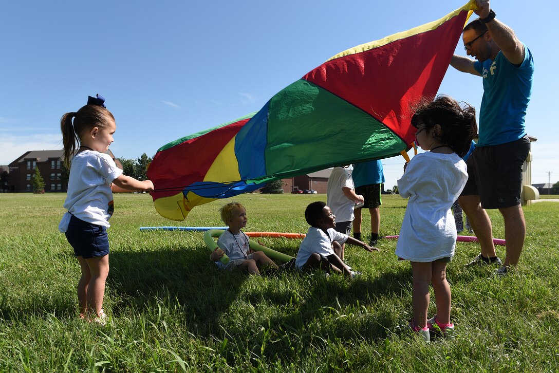 Children play with a parachute at Vacation Bible School at the Chapel Community Center at Ellsworth Air Force Base, S.D., July 21, 2019. Approximately 70 children, ages 6 through 12, participated in the weeklong event, which had songs, bible lessons, cinema time, and outdoor activities. (U.S. Air Force photo by Airman Quentin K. Marx)