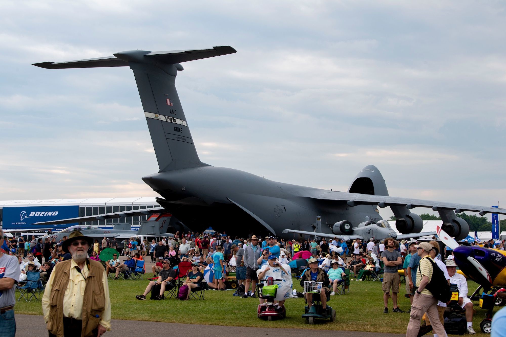 EAA AirVenture attendees watch the airshow in front of a C-5M Super Galaxy July 26, 2019, at Whitman Regional Airport in Oshkosh, Wisconsin. The C-5 crew went to EAA AirVenture 2019 where more than 500,000 aviation enthusiasts from 80 countries gathered at the air show to celebrate the past, present and future in the world of aviation. (U.S. Air Force photo by Senior Airman Jonathon Carnell)