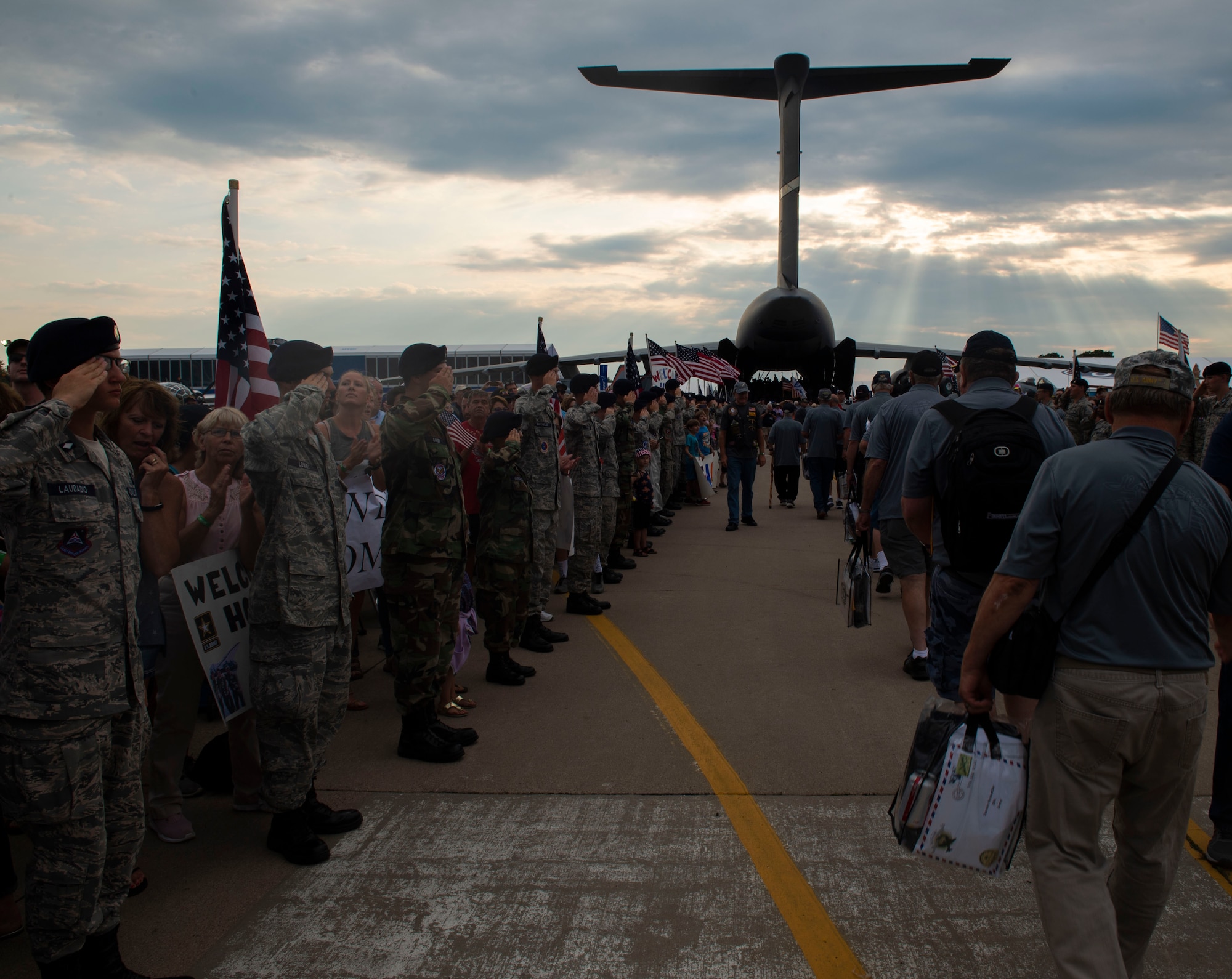 The Old Glory Honor Flight salute and give a welcoming home to veterans who served in the Vietnam War behind a C-5M Super Galaxy July 26, 2019, at Whitman Regional Airport in Oshkosh, Wisconsin. The C-5 crew went to EAA AirVenture 2019 where more than 500,000 aviation enthusiasts from 80 countries gathered at the air show to celebrate the past, present and future in the world of aviation. (U.S. Air Force photo by Senior Airman Jonathon Carnell)