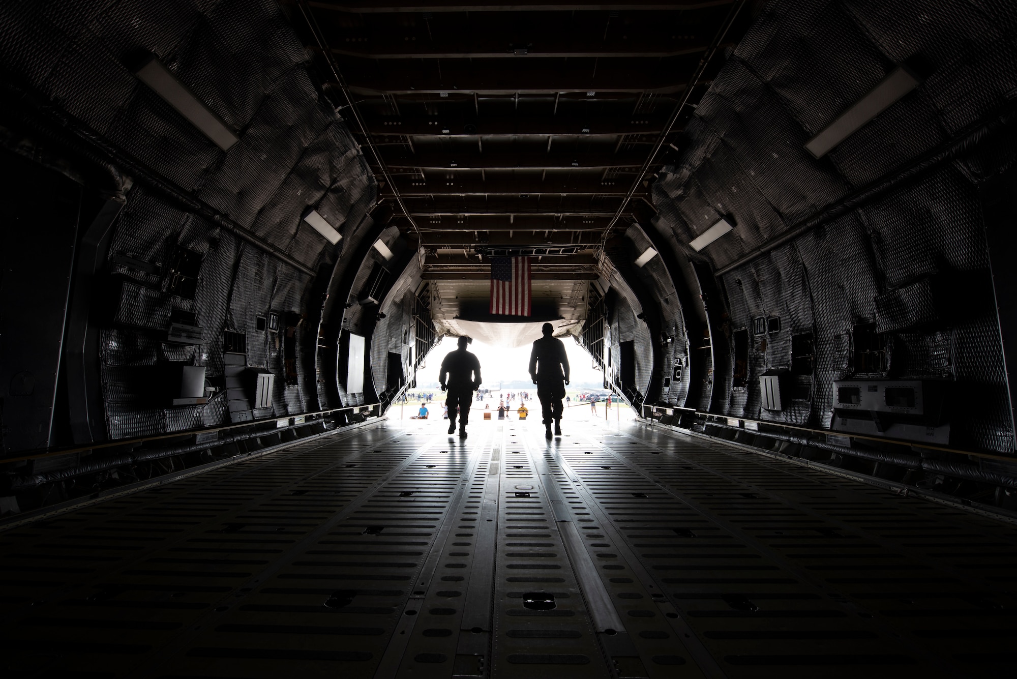 U.S. Air Force Tech. Sgt. Audy Cayanan, 60th Aerial Port Squadron transportation craftsman, left, and Senior Airman Marcus Bueno, 60th APS transportation journeyman, walk toward an exit on a C-5M Super Galaxy July 27, 2019, at Wittman Regional Airport in Oshkosh, Wisconsin. The C-5 crew went to EAA AirVenture 2019 where more than 500,000 aviation enthusiasts from 80 countries gathered at the air show to celebrate the past, present and future in the world of aviation. (U.S. Air Force photo by Senior Airman Jonathon Carnell)