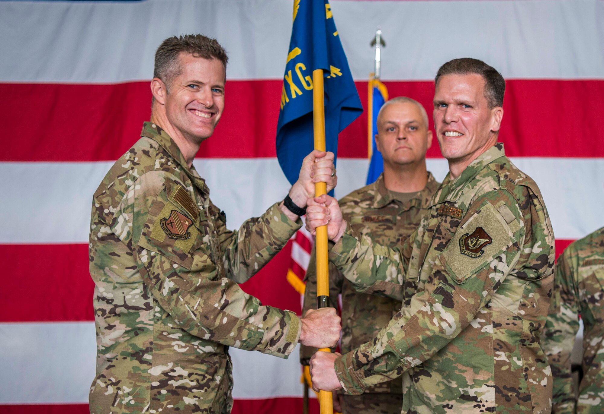 U.S. Air Force Col. Matthew Powell, 354th Maintenance Group commander, accepts the 354th MXG guidon from Col. Benjamin Bishop, 354th Fighter Wing commander, during a change of command ceremony at Eielson Air Force Base, Alaska, July 26, 2019. Powell was previously the commander of the 3rd MXG at Joint Base Elmendorf-Richardson. (U.S. Air Force photo by Senior Airman Isaac Johnson)