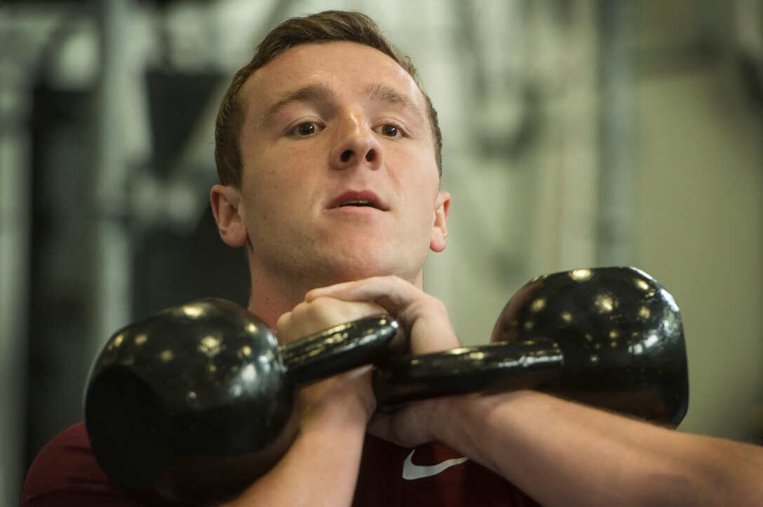 U.S. Air Force 2nd Lt. Jesse Montgomery, Air Force Life Cycle Management Center C-130 Hercules structures engineer, Robins Air Force Base, Ga., raises kettle bells while performing squat exercises during the Alpha Warrior Super Regional event July 27, 2019, at Joint Base Charleston, S.C. Twelve Airmen competed, tackling a variety of functional fitness obstacles, while utilizing the Joint Base Charleston Fitness Center’s Alpha Warrior battle rig. The competition focuses on a competitor’s overall readiness and is designed to promote more fit and resilient service members.