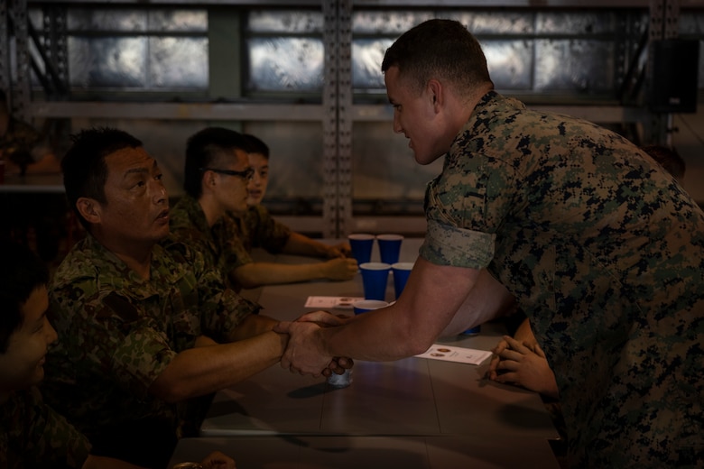 A U.S. Marine shakes hands with a soldier of the Japanese Ground Self-Defense Force during a Mess Night July 22, 2019 at Camp Fuji. The event was put together to build a stronger alliance through a U.S. Marine Corps tradition. (U.S. Marine Corps photo by Lance Cpl. Brennan J. Beauton)