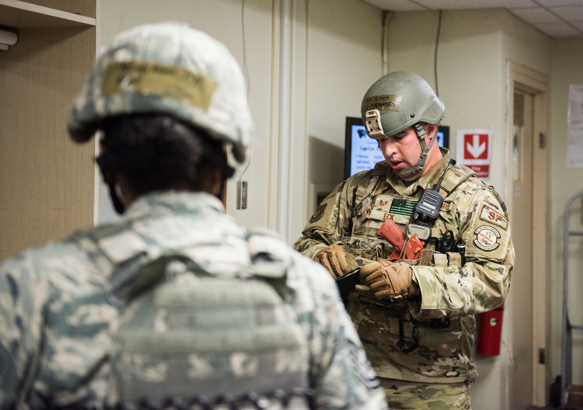 U.S. Air Force Staff Sgt. Brandan Eck (right), and Tech. Sgt. Ashlin Thomas (left), 8th Security Forces Squadron members, search the personal effects of a simulated active shooter during an exercise at Kunsan Air Base, Republic of Korea, July 23, 2019. 8th SFS routinely trains to respond to a variety of threats. (U.S. Air Force photo by Senior Airman Stefan Alvarez)