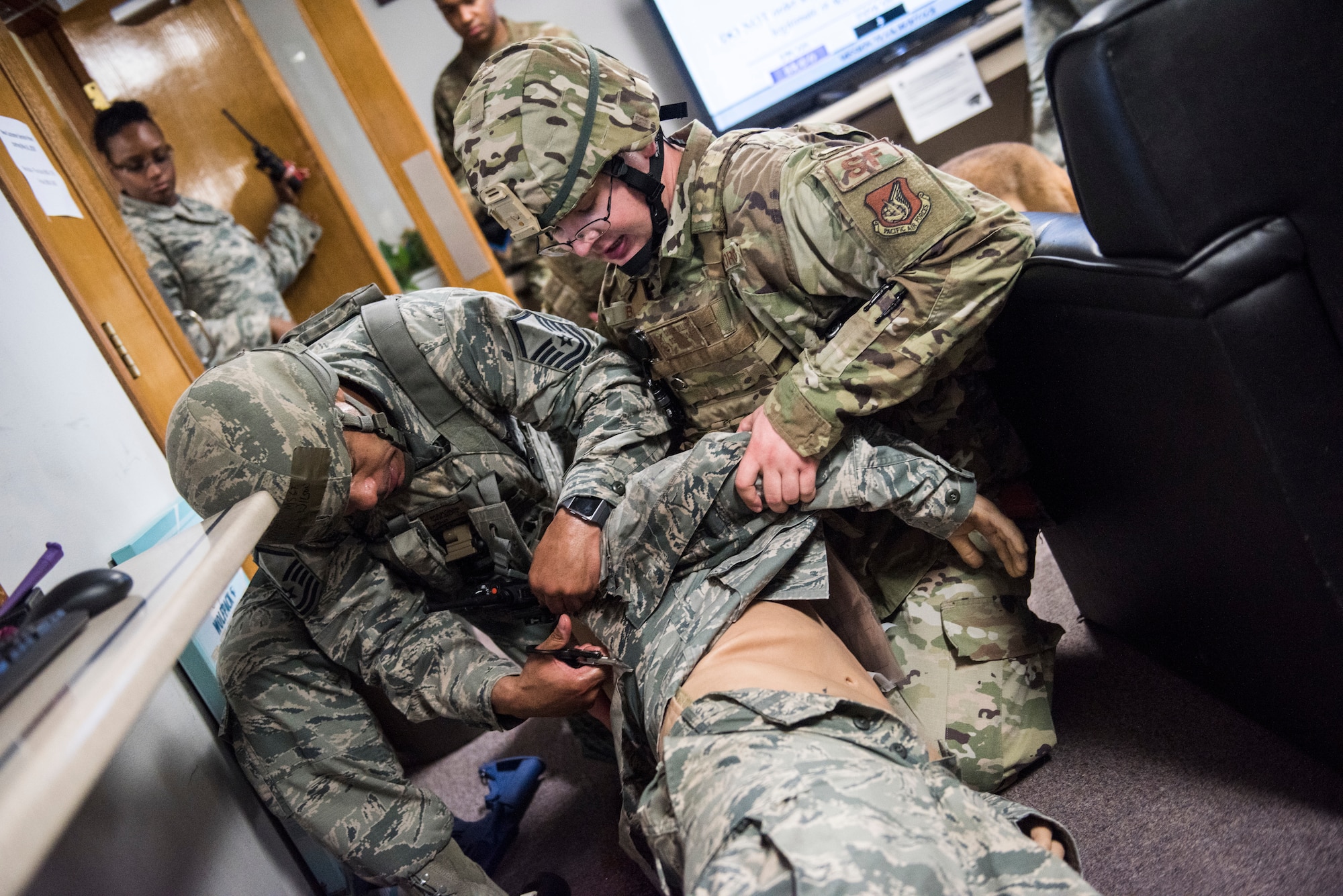 U.S. Air Force Master Sgt. Marquis Wilson (right), and Staff Sgt. Charles Billups (left), 8th Security Forces Squadron members, perform first aid on a simulated victim during an exercise at Kunsan Air Base, Republic of Korea, July 23, 2019. Once alerted, 8th SFS responded with precision to a simulated active shooter call, neutralized the simulated threat and secured the area. (U.S. Air Force photo by Senior Airman Stefan Alvarez)