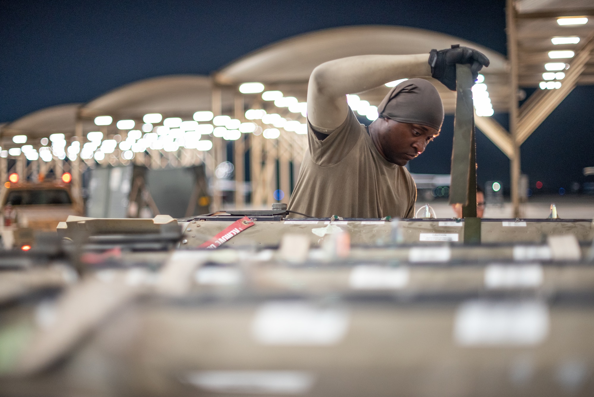 U.S. Air Force Staff Sgt. Kiefer May, 380th Expeditionary Aircraft Maintenance Squadron weapons load crew team chief, straps munitions to a lift July 15, 2019, at Al Dhafra Air Base, United Arab Emirates. Weapons load crews work 24/7 operations to support loading and configuring various munitions for the F-35A Lightning II, F-15E Strike Eagle and F-15C Eagle jets at ADAB. (U.S. Air Force photo by Staff Sgt. Chris Thornbury)