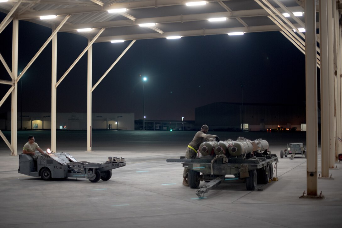 An F-15E Strike Eagle weapons load crew team prepares munitions July 15, 2019, at Al Dhafra Air Base, United Arab Emirates. The F-15E has the capability to carry any air-to surface weapon in the Air Force inventory. (U.S. Air Force photo by Staff Sgt. Chris Thornbury)