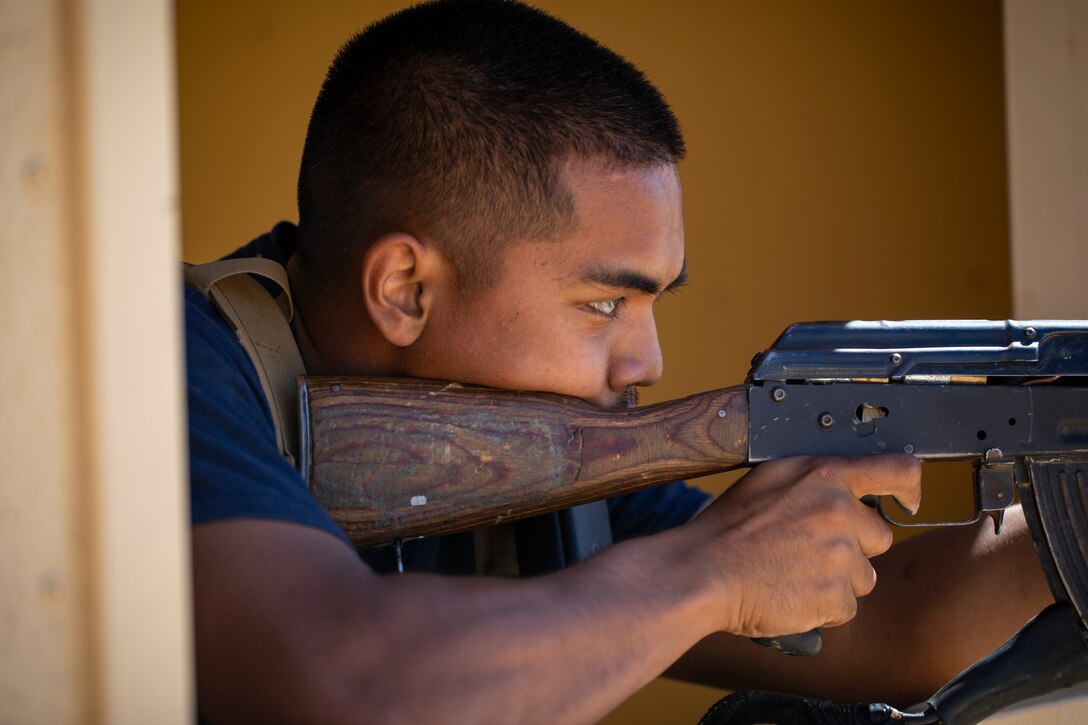 A U.S. Marine posing as an opposing force, shoots blank rounds from an AK-47 rifle towards Marines with 1st Battalion, 25th Marine Regiment, 4th Marine Division, at Marine Corps Air Ground Combat Center Twentynine Palms, Calif., July 30, 2019, during Integrated Training Exercise 5-19. ITX 5-19 is an essential component of the Marine Forces Reserve training and readiness cycle. It serves as the principle exercise for assessing a unit’s capabilities. (U.S. Marine Corps photo by Sgt. Andy O. Martinez)