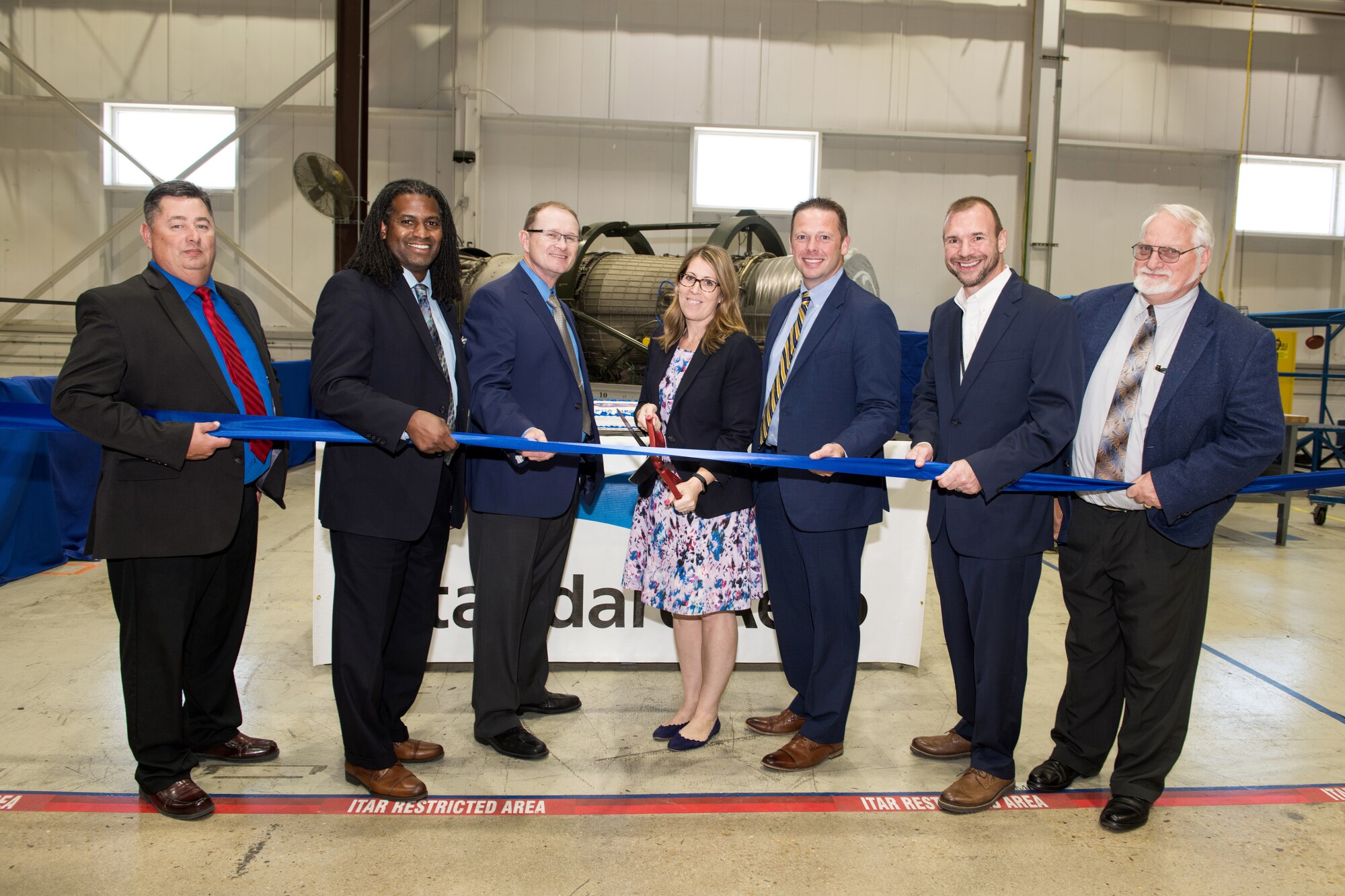 Senior leaders from the United States Air Force, General Electric- Aviation, StandardAero, Defense Logistic Agency-Aviation and Foreign Military Sales pose for a group photo during the ribbon-cutting ceremony held at the StandardAero facilities 25 July, 2019, at Kelly Field, Texas.