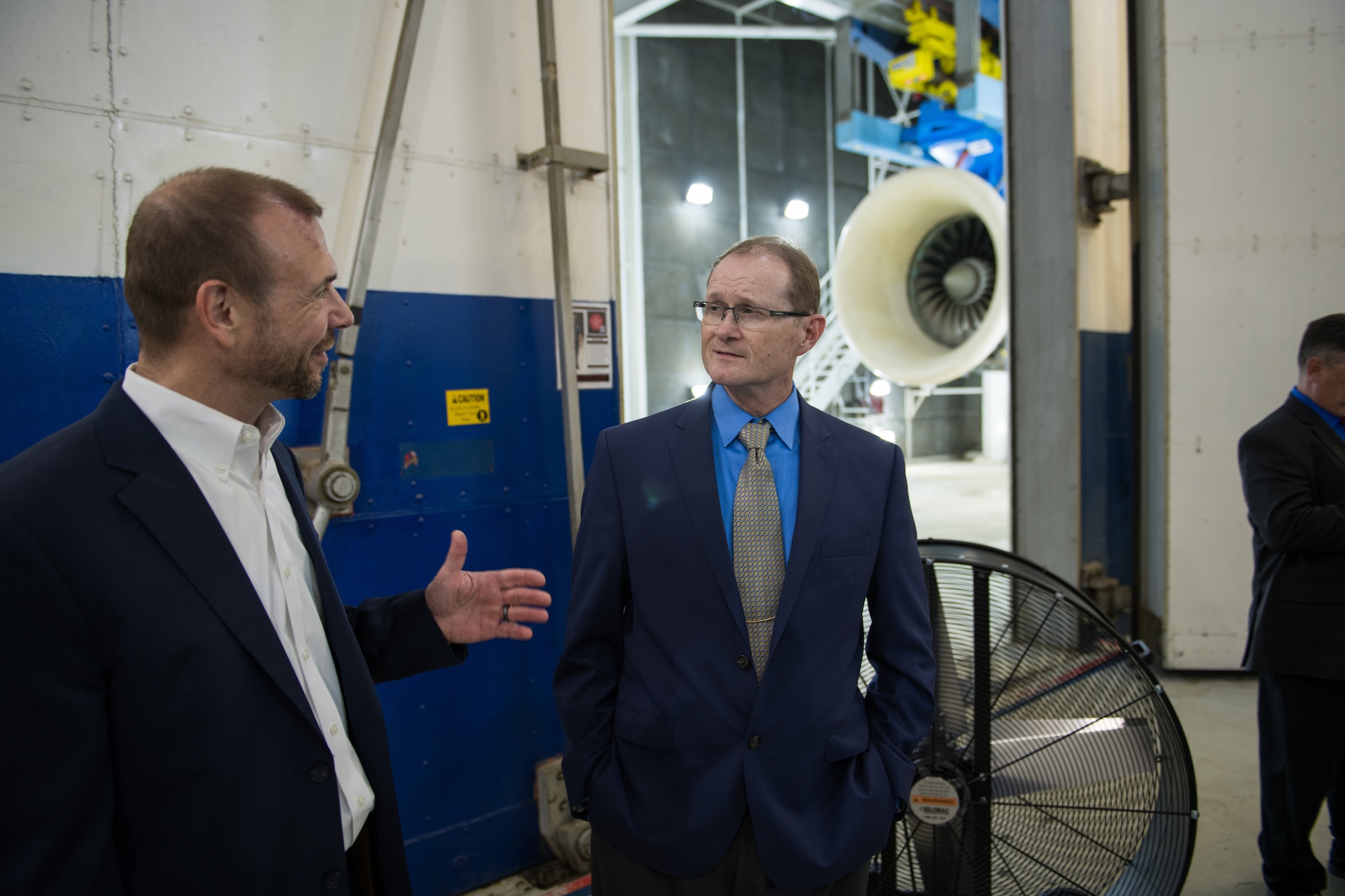 Mark Buongiorno, StandardAero vice-president/general manager (San Antonio), left, talks with Chuck Darnell, Air Force Life-Cycle Management Center Propulsion Sustainment Division director, before the Egyptian Air Force F110 upgrade program ribbon-cutting ceremony held at the StandardAero facilities 25 July, 2019, at Kelly Field, Texas.