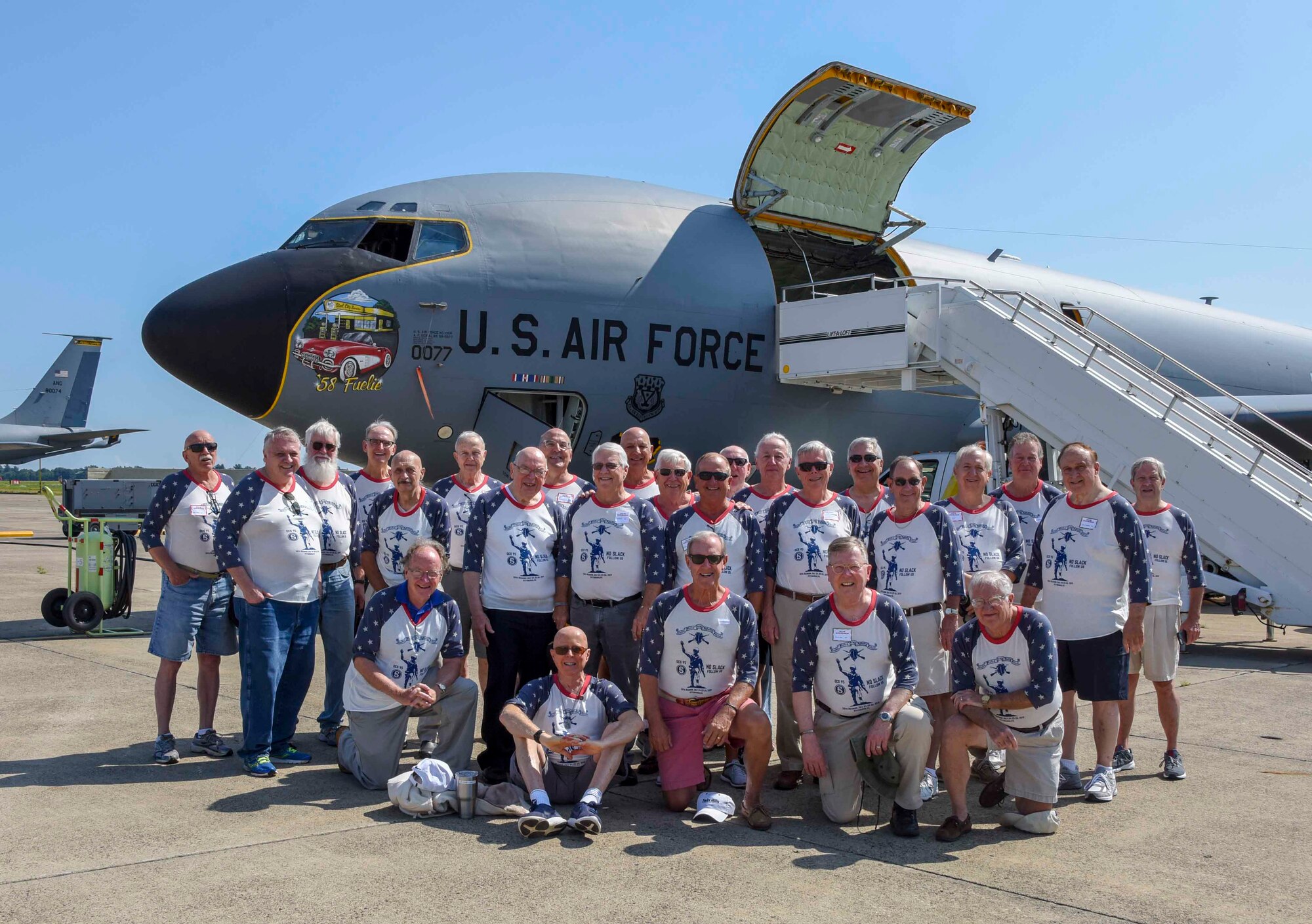 Group of Vietnam veterans pose for a photo in front of a KC-135 aircraft.