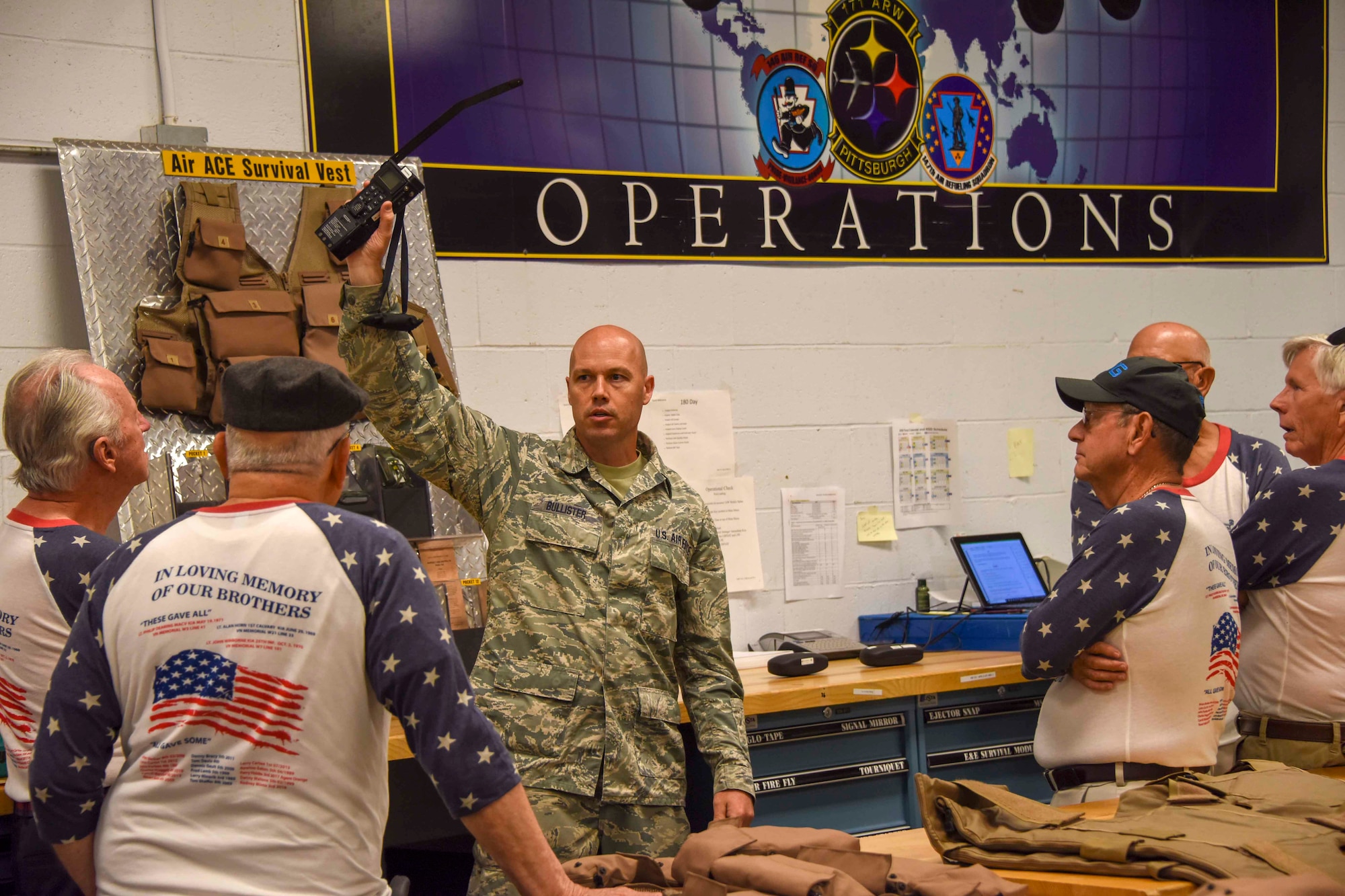 Tech. Sgt. Michael Bullister holds a radio up during a briefing to Vietnam veterans