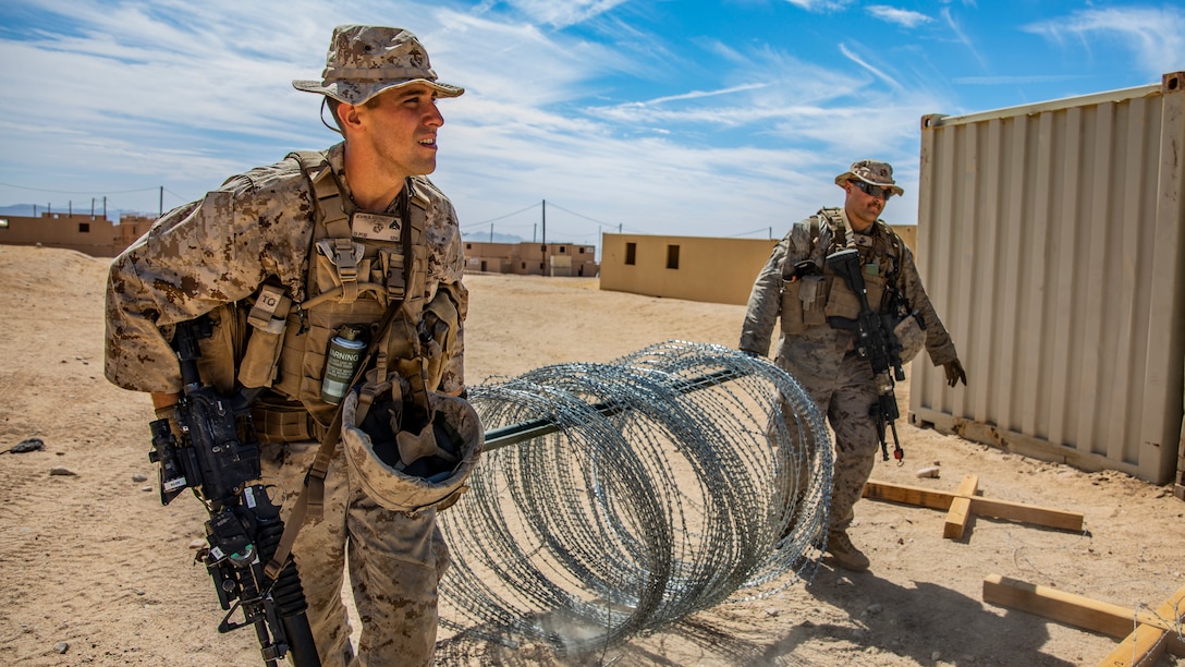 U.S. Marine Corps Cpl. Benjamin A. John, left, a fireteam leader, and Lance Cpl. Tristan A. Castonguay, right, an infantry rifleman, both with 1st Battalion, 25th Marine Regiment, 4th Marine Division, gather concertina wire during Integrated Training Exercise 5-19 at Marine Corps Air Ground Combat Center Twentynine Palms, Calif., July 30, 2019. ITX 5-19 is an essential component of the Marine Forces Reserve training and readiness cycle. It serves as the principle exercise for assessing a unit’s capabilities. (U.S. Marine Corps photo by Lance Cpl. Jose Gonzalez)