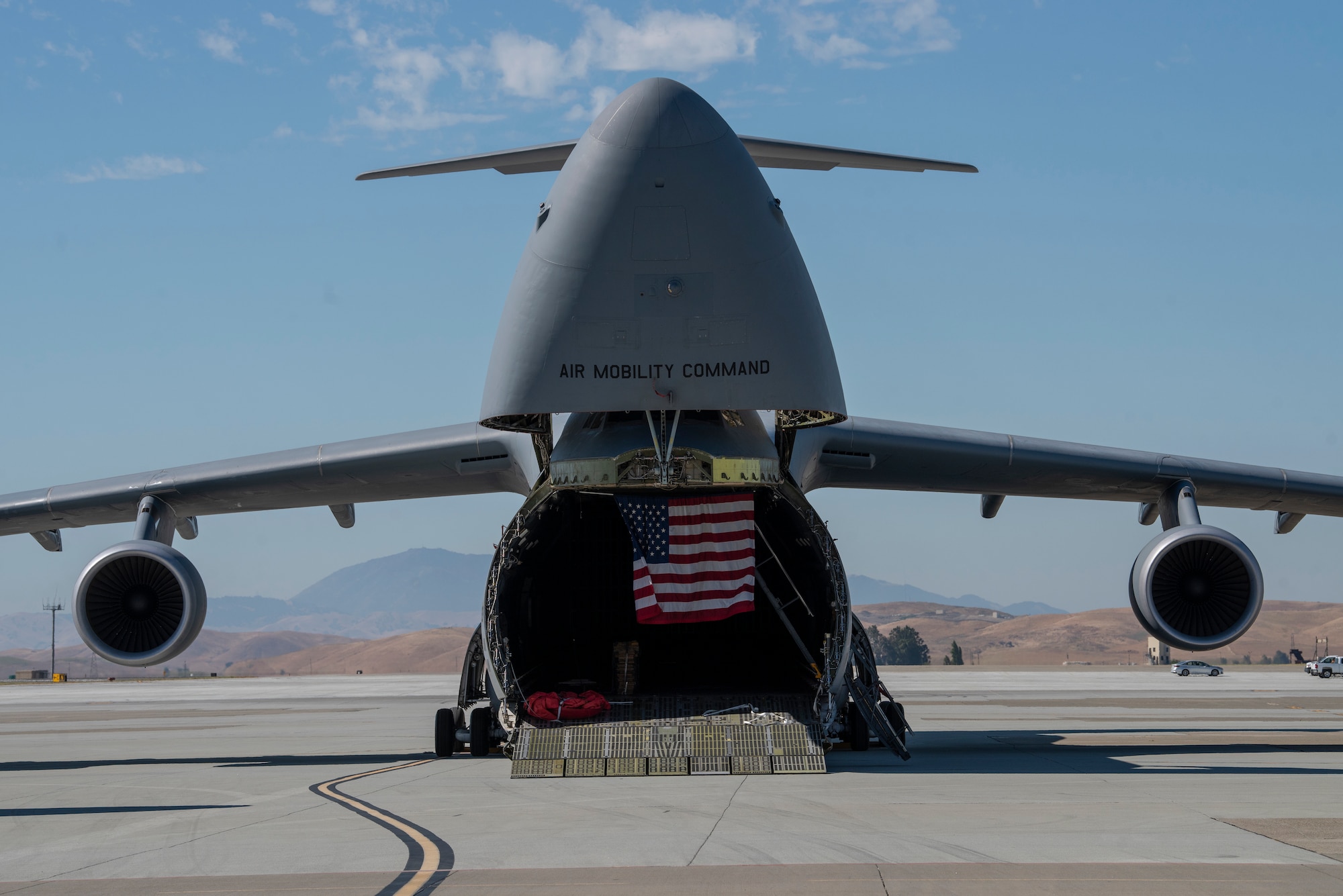 A C-5M Super Galaxy featuring the American flag is part of a static display for the 60th Operations Group change of command ceremony July 26, 2019, at Travis Air Force Base, California. The C-5M was joined in the display by a KC-10 Extender and C-17 Globemaster III. During the ceremony, U.S. Air Force Col. Theresa Weems, outgoing 60th OG commander, transferred command to Col. Gregg Johnson. (U.S. Air Force photo by Tech. Sgt. James Hodgman)