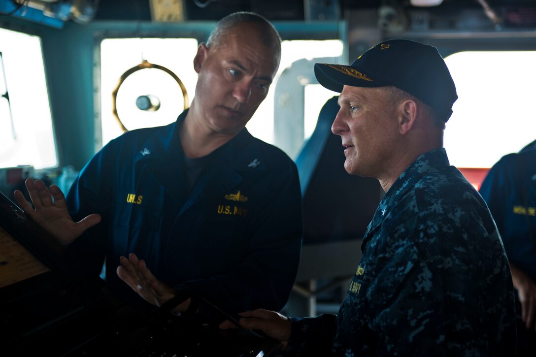 Two Navy officers talk.