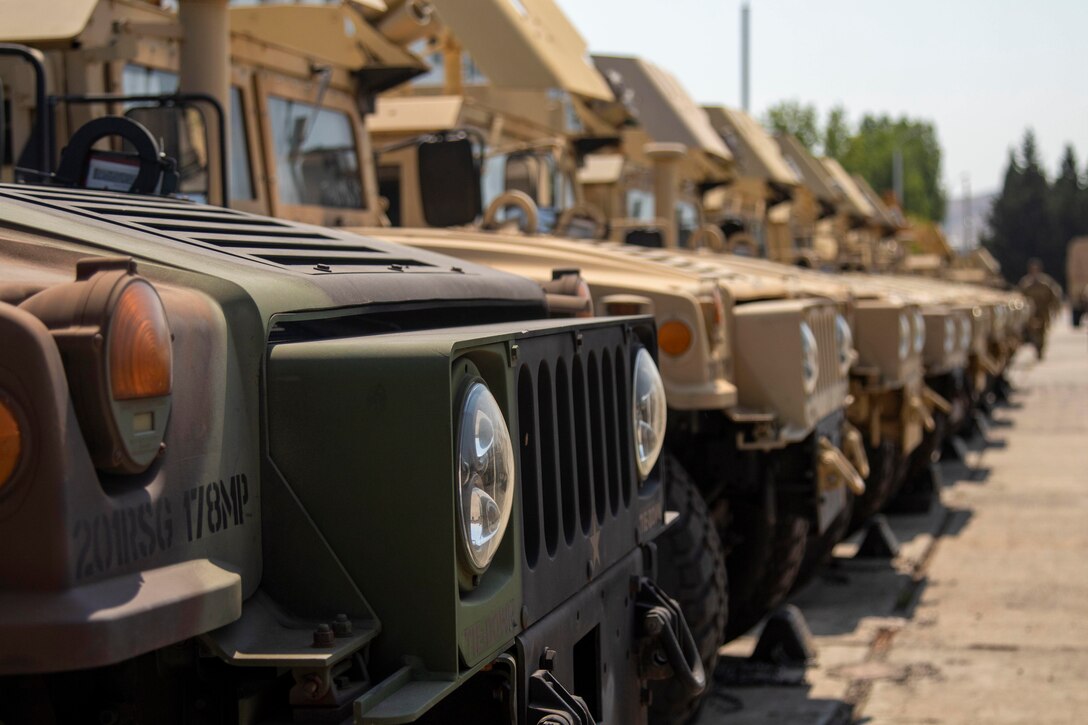 A group of Humvees parked in a line.