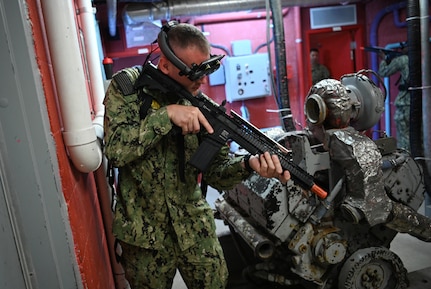 IMAGE: 190613-N-PO203-0232 CHESAPEAKE, Virginia (Jun. 13, 2019) A Sailor assigned to the Center for Security Forces detachment in Chesapeake, Va., demonstrate the Office of Naval Research Global (ONRG) TechSolutions-sponsored Tactically Reconfigurable Artificial Combat Enhanced Reality (TRACER) system. TechSolutions partnered with Naval Surface Warfare Center Dahlgren Division to develop the TRACER package, which consists of a virtual-reality headset, a backpack, a state-of-the-art simulated weapon designed to deliver realistic recoil, and a software package that creates multiple and adaptable simulation scenarios for security personnel to experience. ONRG TechSolutions allows Sailors and Marines to submit technology requests directly to the development community for rapid response prototyping. (U.S. Navy photo by John F. Williams)