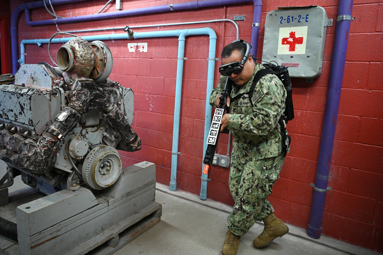 IMAGE: 190613-N-PO203-0259 CHESAPEAKE, Virginia (Jun. 13, 2019) A Sailor assigned to the Center for Security Forces detachment in Chesapeake, Va., demonstrate the Office of Naval Research Global (ONRG) TechSolutions-sponsored Tactically Reconfigurable Artificial Combat Enhanced Reality (TRACER) system. TechSolutions partnered with Naval Surface Warfare Center Dahlgren Division to develop the TRACER package, which consists of a virtual-reality headset, a backpack, a state-of-the-art simulated weapon designed to deliver realistic recoil, and a software package that creates multiple and adaptable simulation scenarios for security personnel to experience. ONRG TechSolutions allows Sailors and Marines to submit technology requests directly to the development community for rapid response prototyping. (U.S. Navy photo by John F. Williams)