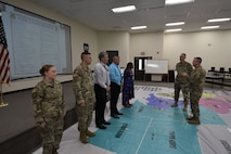 Four military and 3 civilians, in briefing room.