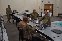 Three male Soldiers at table and one female Soldier.