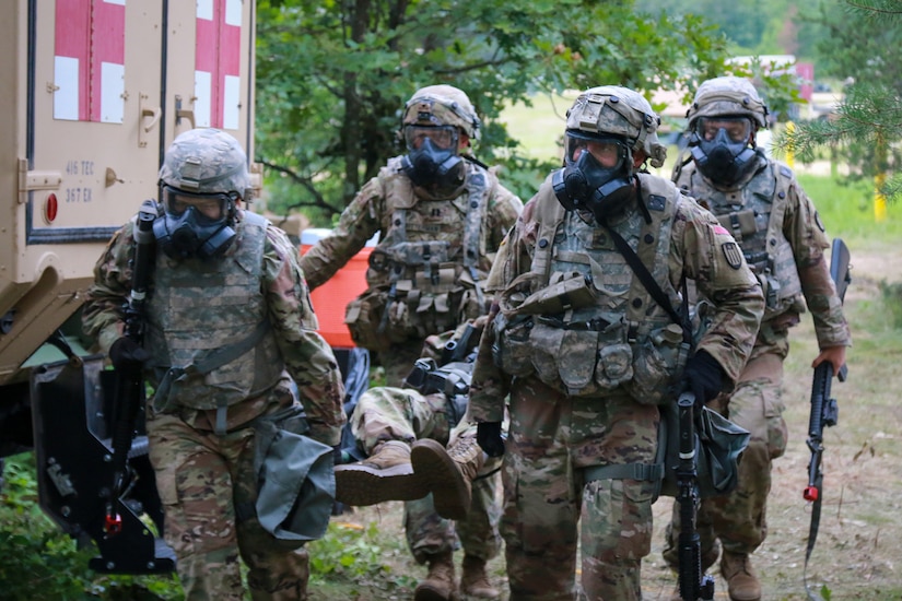 Soldiers wearing gas masks transport litter.