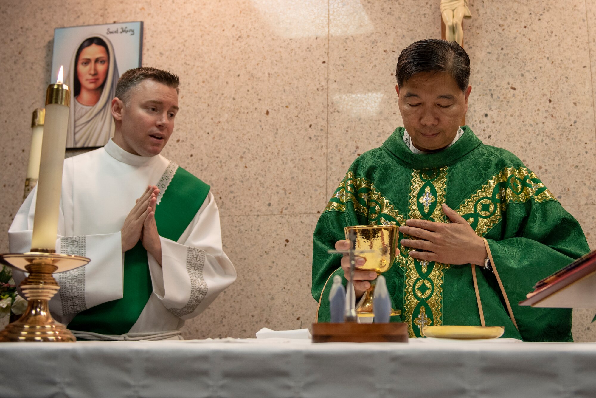 2nd. Lt. Tyler Harris, Air Force Reserve Command chaplain candidate out of Robins Air Force Base, Georgia, assists Capt. Antonio Rigonan, 374th Airlift Wing chaplain, with Catholic Mass at Yokota Air Base, Japan, July 2, 2019.