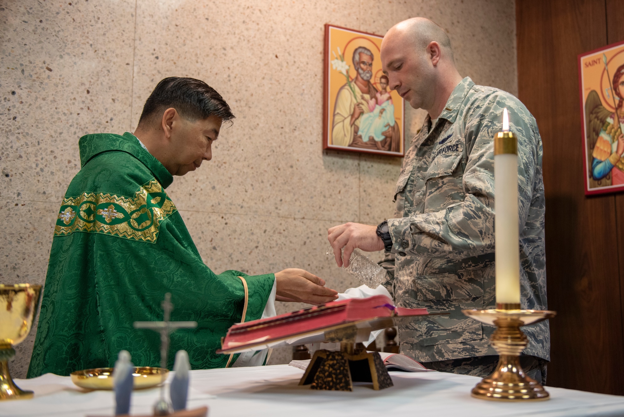 2nd. Lt. Madison Hayes, Air Force Reserve Command chaplain candidate out of Robins Air Force Base, Georgia, assists Capt. Antonio Rigonan, 374th Airlift Wing chaplain, with Catholic Mass at Yokota Air Base, Japan, July 2, 2019.