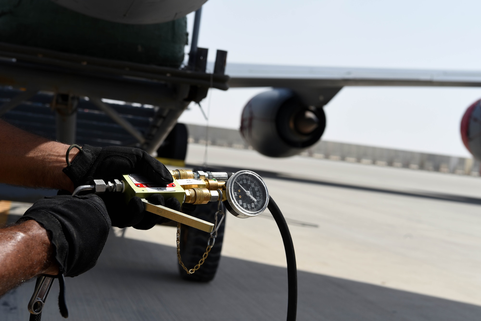 Senior Airman David Morris, 385th Expeditionary Aircraft Maintenance Squadron crew chief, tests a pressure gauge at Al Udeid AB, Qatar, June 1, 2019. The combination of Air Mobility Liaison Officers, maintainers and support personnel, gives the 385th the ablility to provide options to the Combined Forces Air Component Commander including but not limited to airland (air assets supporting land forces), airdrop, and aerial refueling. (U.S. Air Force photo by Staff Sgt. Ashley L. Gardner)
