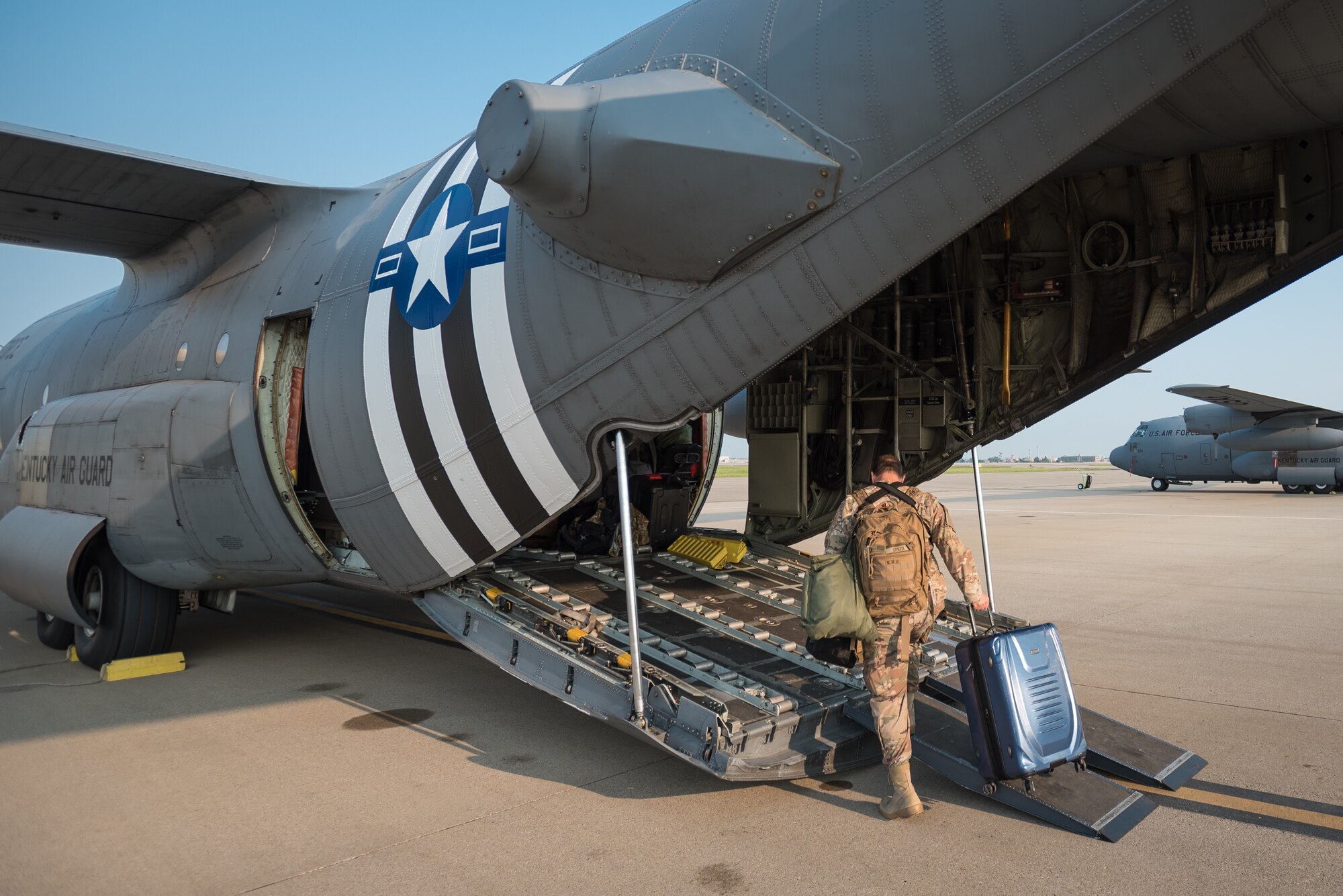 Master Sgt. Phil Speck, Public Affairs superintendent for the 123rd Airlift Wing, boards a C-130 Hercules aircraft at the Kentucky Air National Guard Base in Louisville, Ky., June 1, 2019, en route to France. Speck and 30 other Kentucky Air Guardsmen will participate in the 75th-anniversary reenactment of D-Day there. Two Kentucky C-130s will airdrop U.S. Army paratroopers over Normandy on June 9 as part of the commemoration. The aircraft has been striped with historically accurate Allied Forces livery in honor of the event, which turned the tide of World War II in the European theater. (U.S. Air National Guard photo by Dale Greer)