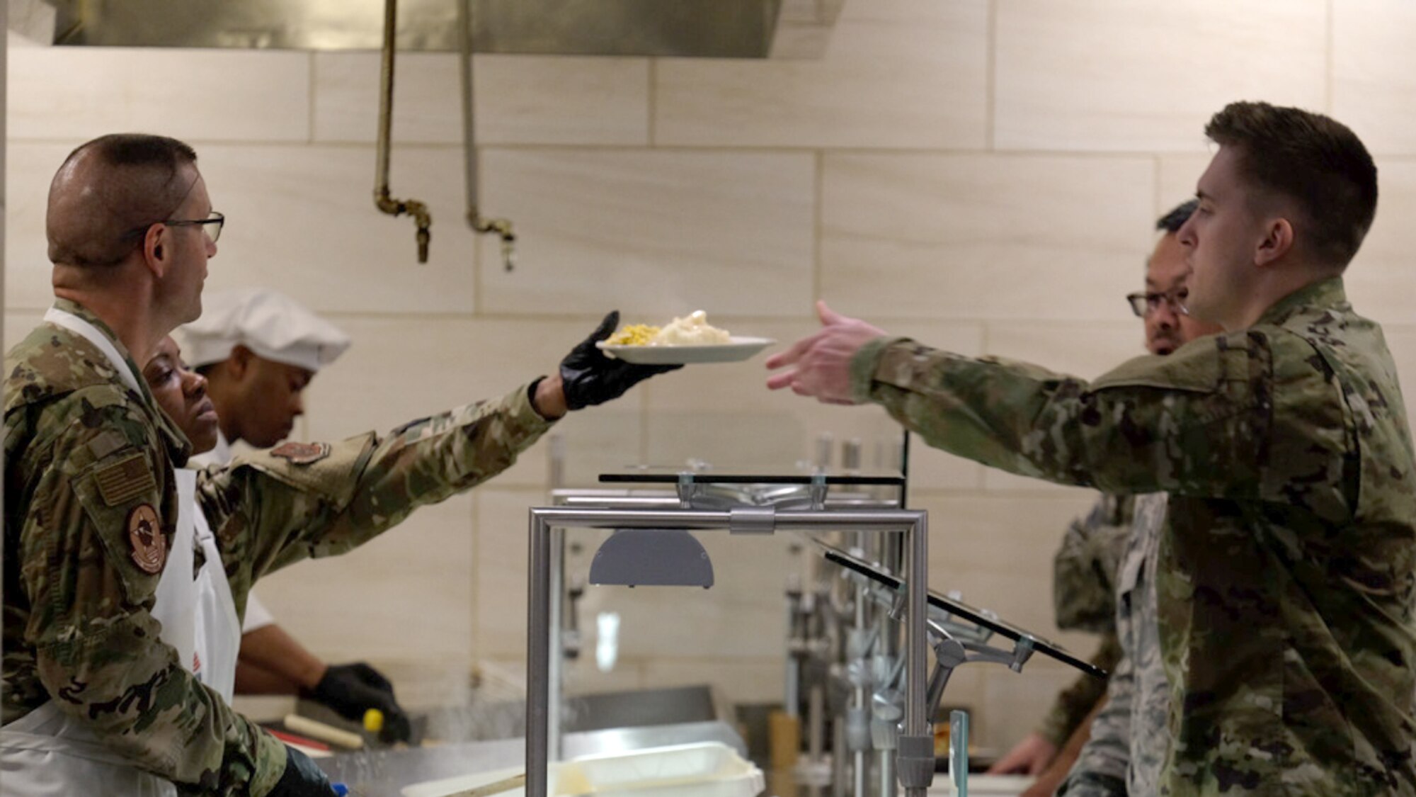 Col. Phil Heseltine, 931st Air Refueling Wing commander, and Chief Master Sgt. Takesha Williams, 931st ARW command chief and 507th Air Refueling Wing budget analyst, serve lunch to Team McConnell Airmen June 1, 2019, in the Chisholm Trail Dining Facility on McConnell Air Force Base, Kan.