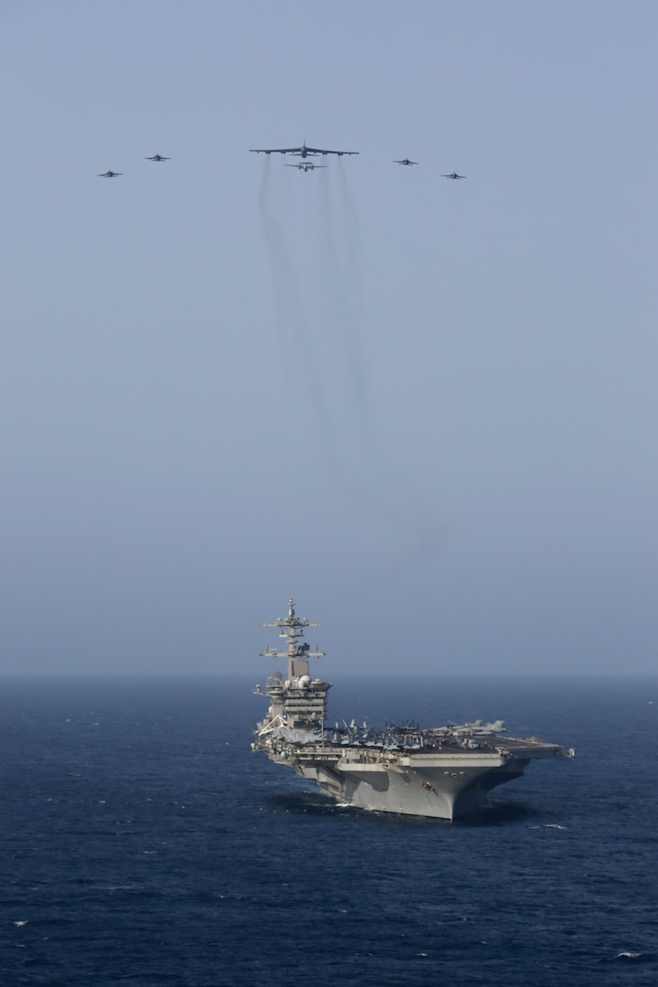 A photo of B-52 and Abraham Lincoln Carrier Strike Group.