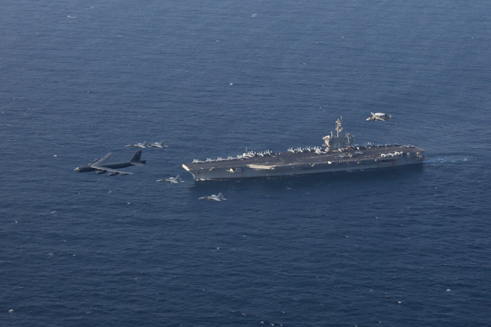 A photo of Abraham Lincoln Carrier Strike Group and a B-52.