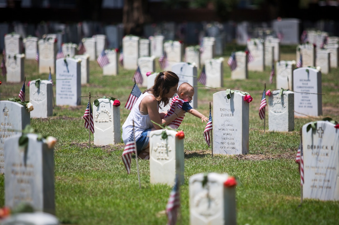 A local mother and her child put a single rose on the grave of a service member during the City of Beaufort’s Annual Memorial Day Parade and remembrance ceremony May 27, 2019 at Beaufort National Cemetery in Beaufort, S.C. The Tri-Command and local community held the parade to remember and honor the men and women who have served and died in the service of the nation in the U.S. Armed Forces. (U.S. Marine Corps photo by Lance Cpl. Christopher McMurry)