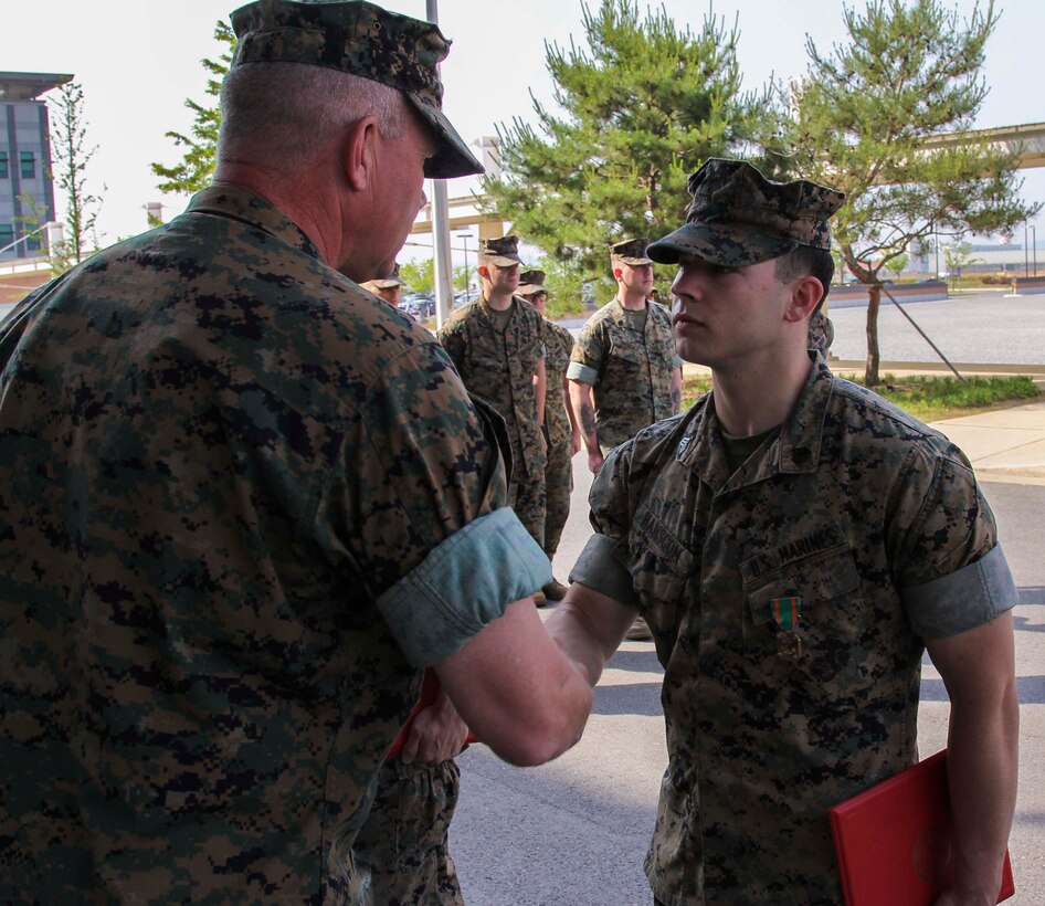 CAMP HUMPHREYS, Republic of Korea – Sgt. Nathaniel Hanscom, communication strategy and operations NCO for U.S. Marine Corps Forces Korea, is awarded the Navy and Marine Corps Achievement Medal here, June 3rd. Hanscom was awarded for his contributions to MARFORK as a photographer for the unit, telling of its history and story, as well as documenting and archiving events for the unit. (Official U.S. Marine Corps photo by 1stLt. Edward Pingel/Released)