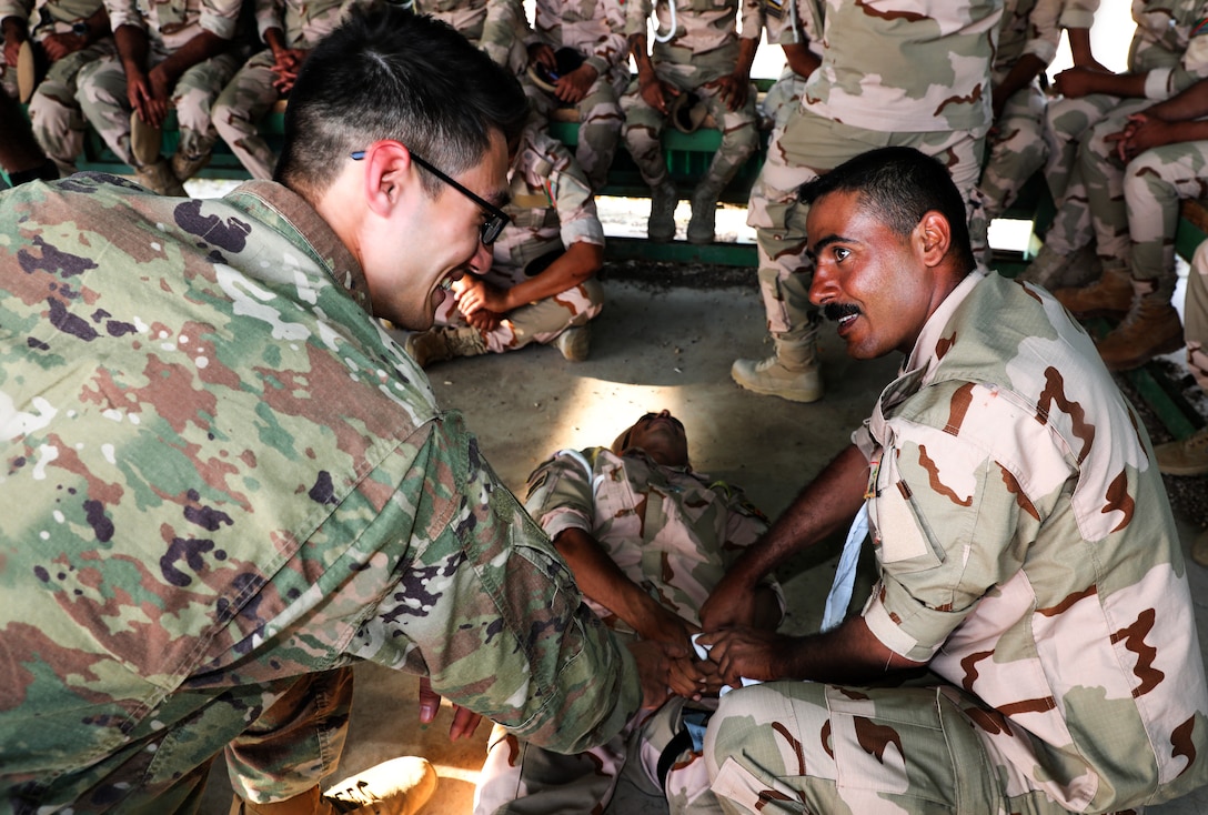 U.S. Army Cameron Buehler with Charlie Troop, 1-32nd Cavalry, 1st Brigade, demonstrates how to use combat gauze, on Camp Taji, Iraq, May 6, 2019. Combined Joint Task Force – Operation Inherent Resolve focuses on providing training, support, and equipment to enhance the professionalism, technical expertise and equipment capabilities of Iraqi Security Forces. This will enable the ISF to counter future external and internal threats independently and establish permanent security across the country. (Portions of this photo have been blurred to protect operational security).