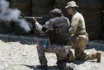 A Soldier from the Florida Army National Guard advises a Haitian Soldier on the proper handling technique of a shotgun.