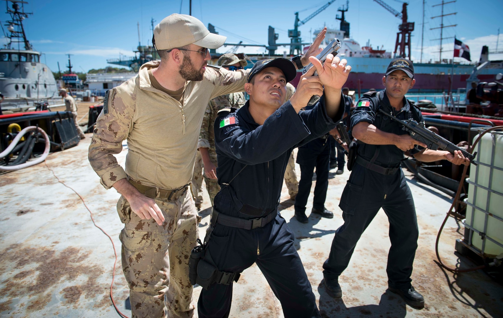 A member of the Canadian Naval Tactical Operations Group provides Mexican Navy personnel with techniques on how to secure the perimeter of a vessel.