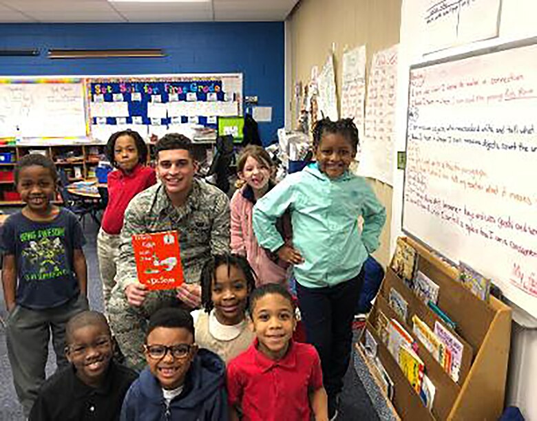 Airman 1st Class Kyle Valerio, assigned to the 718th Intelligence Squadron, serves as a mentor for young children at Bassette Elementary school, reading as a part of the Mayor’s Book Club to promote interest in books and literacy.
