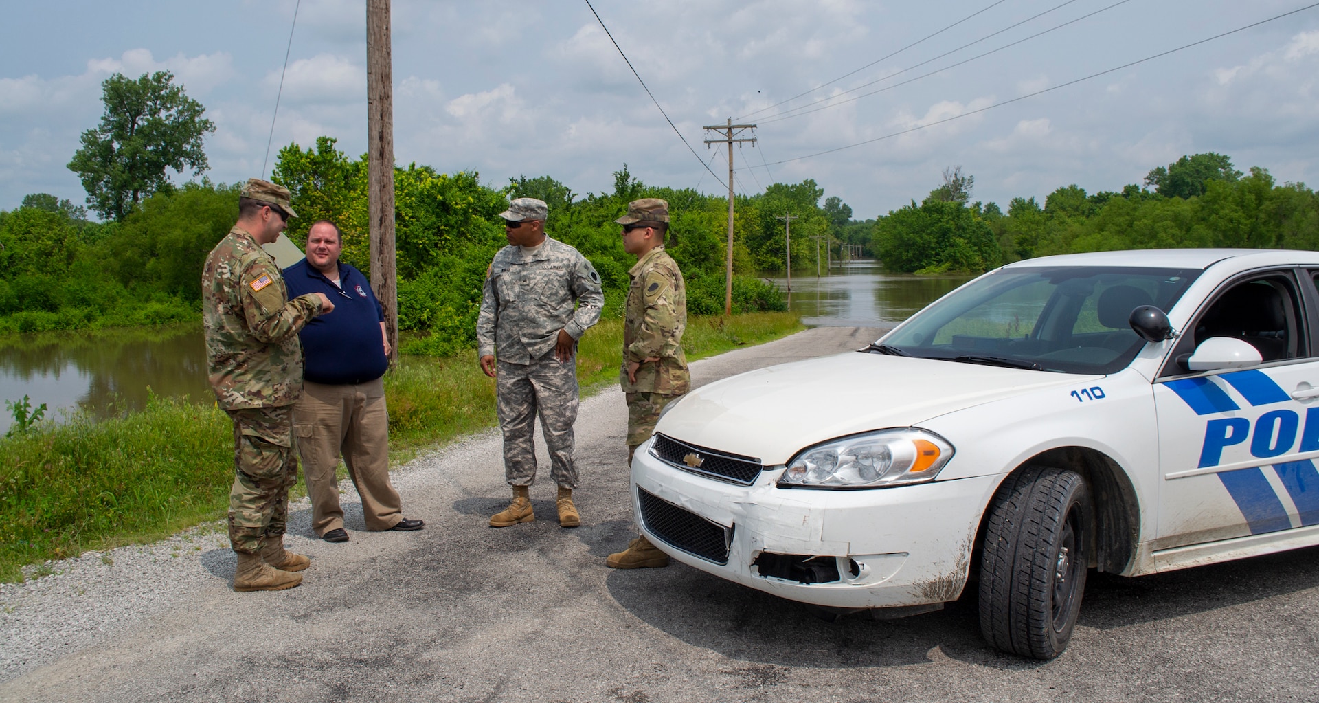 Sgt. Joey White, of Chicago, Pfc. Andrew Gusich, of Mendota, and Spec. Eder Castillo, of Rochelle, discuss levee patrol operations