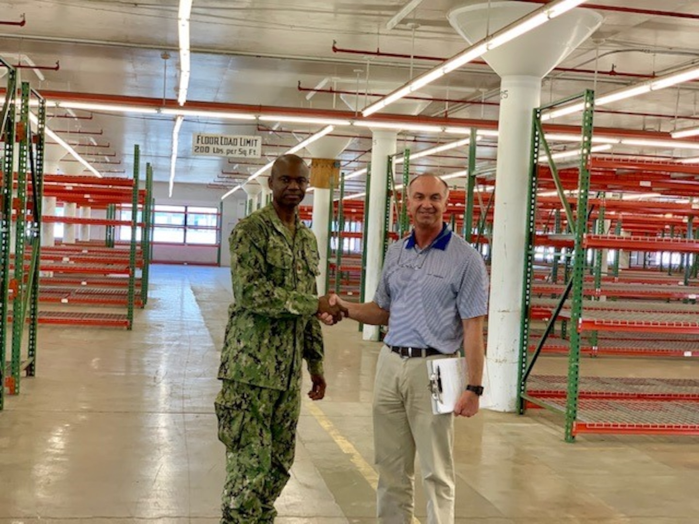 Terry Surdyke, an area manager for DLA Disposition Services’ South-East region, and Navy Lt. Cmdr. Jay McFarland, operations officer at Jacksonville’s Fleet Logistics Center, celebrate the clearing of Building 110.