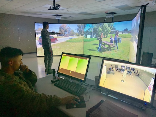 Airman 1st Class Valric Suyom, a recent graduate of the Security Forces apprentice course, participates in a use of force training scenario in the Multiple Interactive Learning Objectives (MILO) simulator as Staff Sgt. James McKinney, 343rd Training Squadron instructor, guides the training at Joint Base San Antonio-Lackland, Texas, May 29, 2019. The MILO system puts student in various interactive use of force training scenarios, including the potential application of deadly force, through the use of enhanced video screens.  (U.S. Air Force photo by Dan Hawkins)