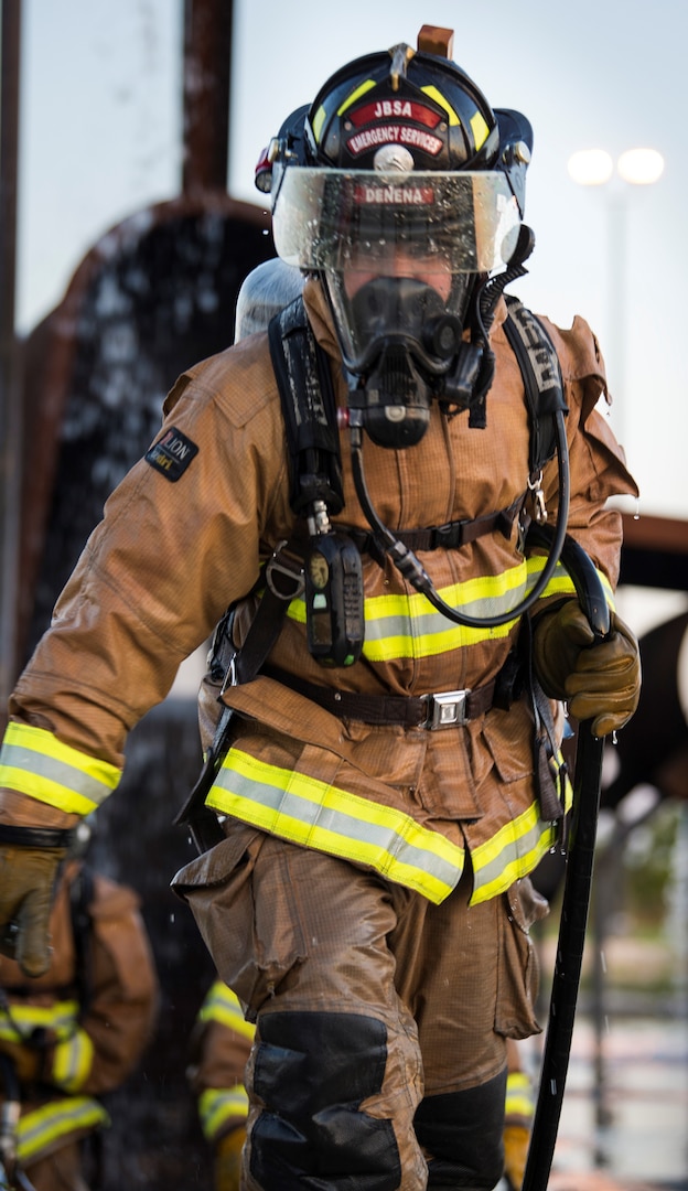 A firefighter from Joint Base San Antonio-Randolph carries a hand line during training April 11, 2018 at the Camp Talon fire training grounds on JBSA-Randolph. The training offers firefighters the opportunity to train with live fire to get as close to a real-life scenario as possible.
